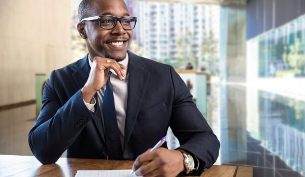 Smiling cheerful happy african american male business executive sales representative at luxury building lobby